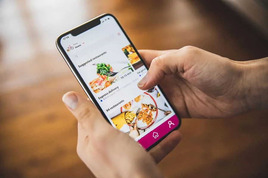 móvil con una app de delivery abierta sobre qcommerce